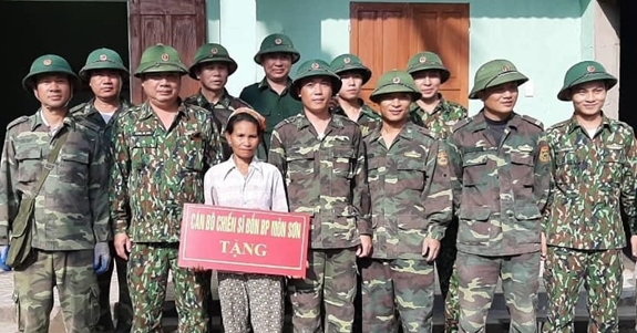 Cán bộ, chiến sĩ Đồn Biên phòng Môn Sơn và bà La Thị Mừng trước ngôi nhà mới.